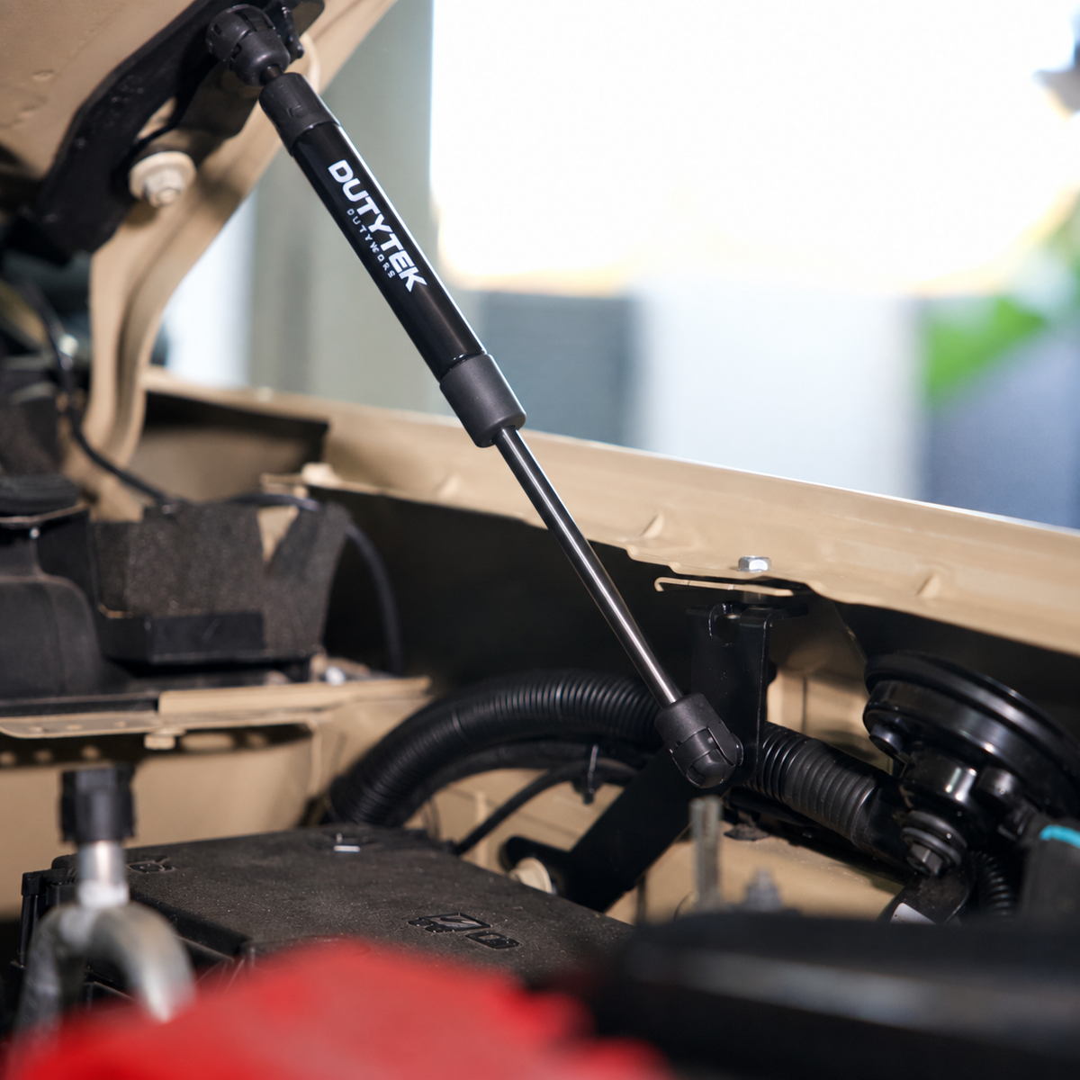 DUTYTEK bonnet strut installed in a Ford Ranger engine bay with the thick cylinder above the slim rod